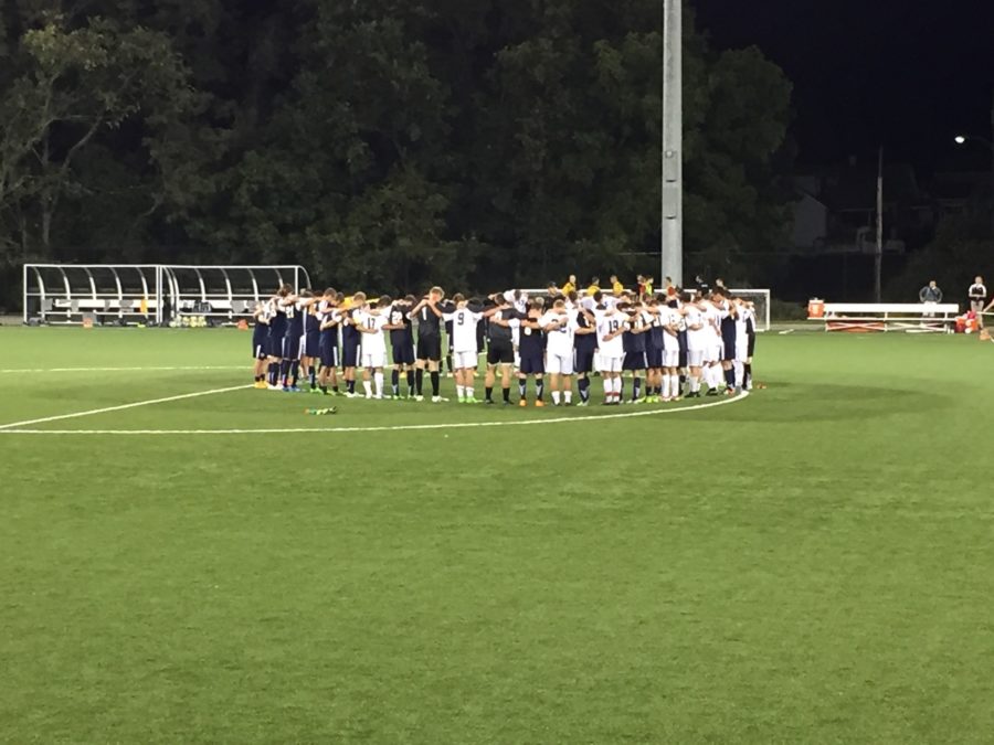 Players+from+both+Cal+U+and+Cedarville+gather+in+the+center+of+the+field+after+the+game+to+pray.