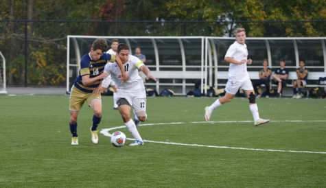 Eleazar Luciano, senior, fights to get past Pitt-Johnstown's player.