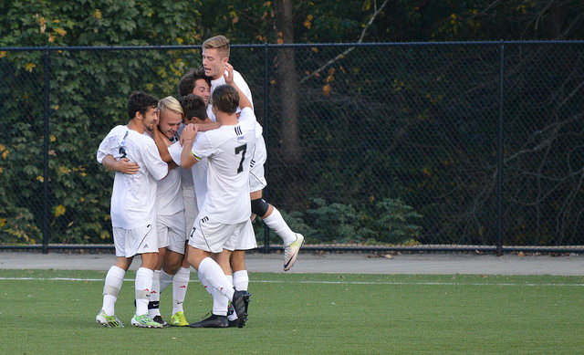 Members of Cal Us mens soccer team celebrate after a goal.