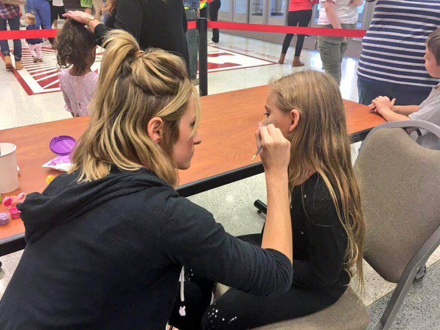 McKena Dunn paints the face of one of the many excited children in attendance.