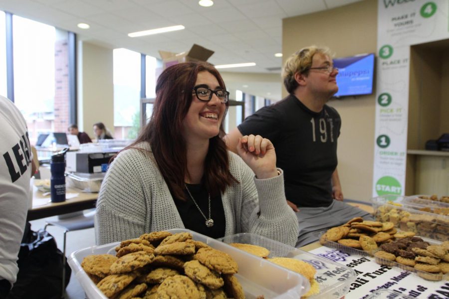 Members of Cal Us S.T.A.N.D. organization offering free cookies to visitors in the Natali Student Center during back-to-school week, 2019