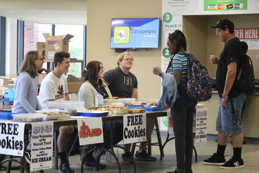 Members of Cal Us S.T.A.N.D. organization offering free cookies to visitors in the Natali Student Center during back-to-school week, 2019