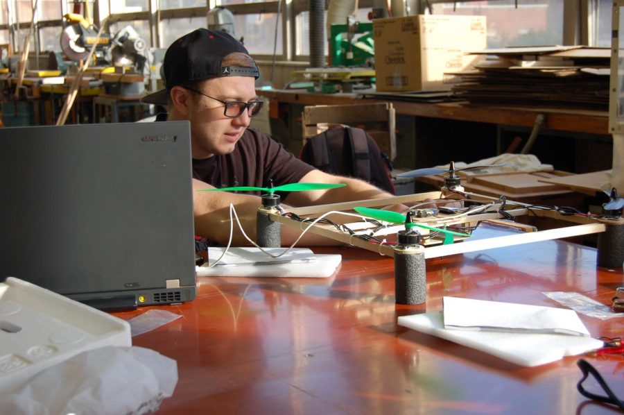 A college student prepares an unmanned aerial system for flight. 