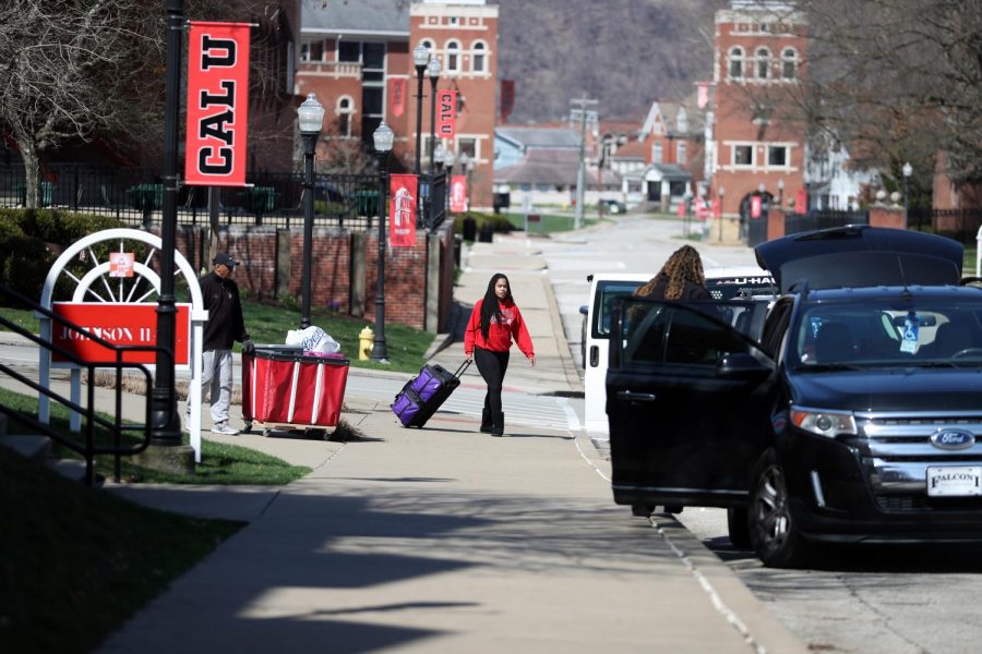 Alyssa Emerson, freshman,  Aliquippa, Pa. pulls a suitcase and is met by her parents, Marvin and Felisa Emerson, as she moves out of Johnson Hall on March 22, 2020.
