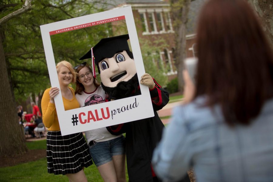 Students+pose+for+a+photo+with+mascot+Blaze+at+the+Cal+U+Commencement%2C+May+11%2C+2018.