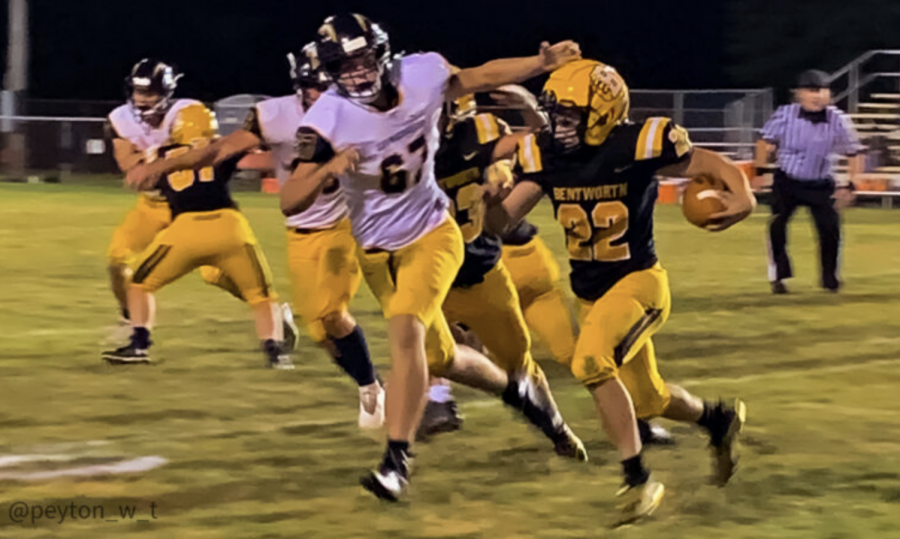 Bentworth Senior Owen Petrisek (#22, black) runs the ball while junior Elijah Smith (#67, white) tries to take him down.