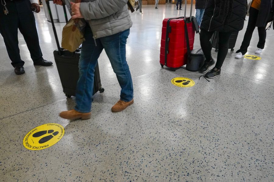 Yellow dots mark the spots for proper social distancing as travelers line up to board an Amtrak train , Tuesday, Nov. 24, 2020, in New Yorks Penn Station.  Gov. Andrew Cuomo urged New Yorkers to just say no to Thanksgiving gatherings to help reduce COVID-19 infections and hospitalizations, which he said are rising at a dangerous level.