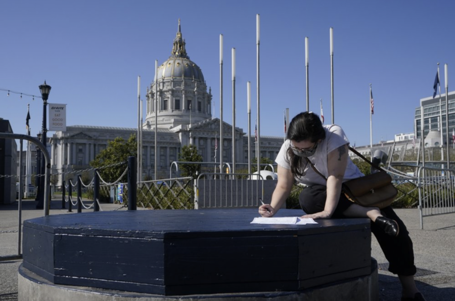 Andie Grossman fills out her ballot before delivering it to a San Francisco Department of Elections voting center in San Francisco, Sunday, Nov. 1, 2020. 