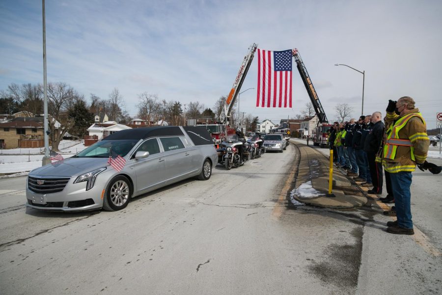 California and West Brownsville Vol. Fire Departments aerial ladders join to support a U.S. flag over Wood Street for the funeral procession of Timothy Sheehan, chief of police, California, Pa. on Feb. 17, 2021.