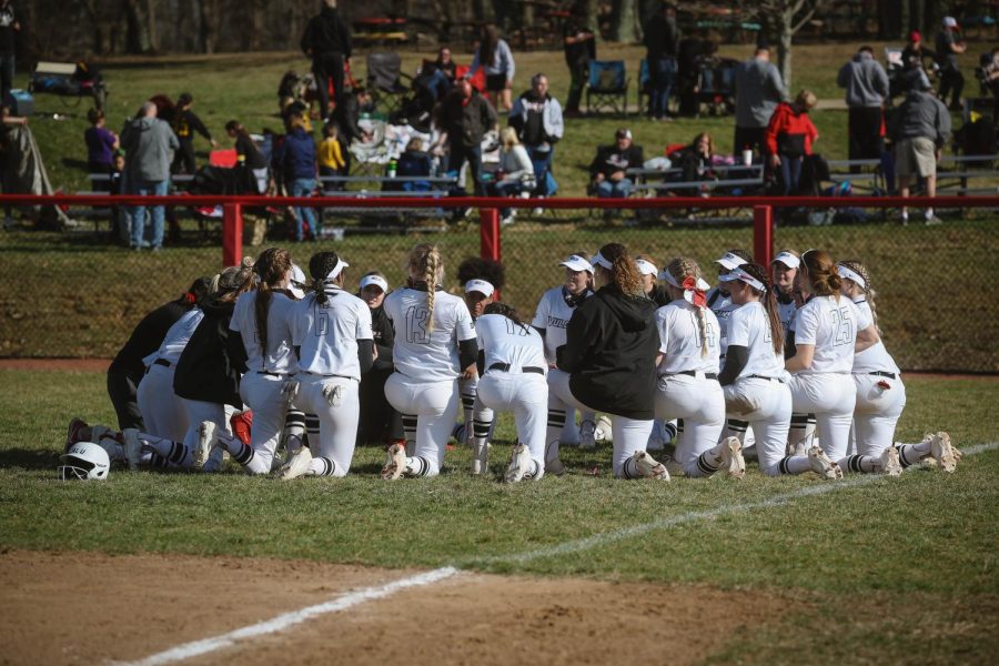 Cal softball team gathers for a post-game discussion with the coaching staff.