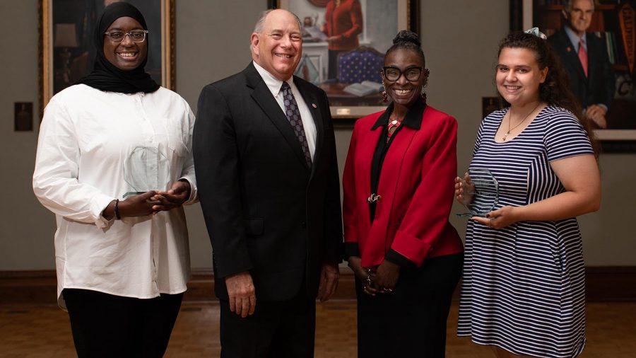 Interim University President Bob Thorn and Shelta Camarda-Webb, Interim Chief Diversity, Equity and Inclusion Officer, present Fatouma Keita, left, with the Jennie Carter Distinguished African American Student Award and Kimberly Melck, right, with the Jan Zivic Outstanding LGBTQ+ Leadership Award.