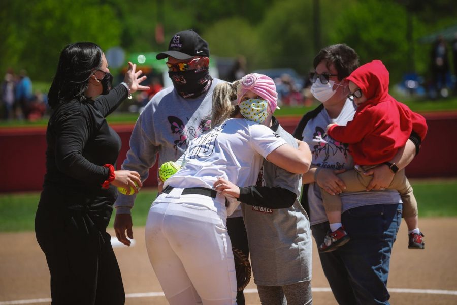Cal U softball catcher Brooke Wilson hugs 11-year-old Olivia Sealy after throwing the first pitch at the Cal U softball game at Lilley Field on May 1, 2021.