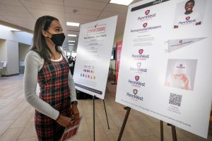 Cal U student Destiny Brooks looks at the display of proposed logos of Pennsylvania Western University, the integrated university of California, Clarion and Edinboro, Oct. 19, 2021.