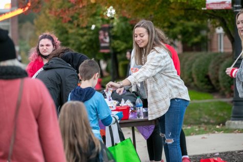 Cal U student government president Caitlyn Urban handing candy to children at the Meet and Treat event. 