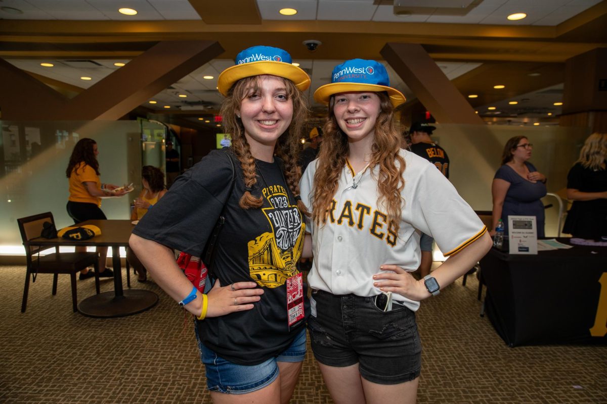 Student Trustees Rachel Kister ’24, Clarion, and Sarah Seader ’24, California showcase the reversable PennWest bucket hat and the Yinzerpalooza t-shirt