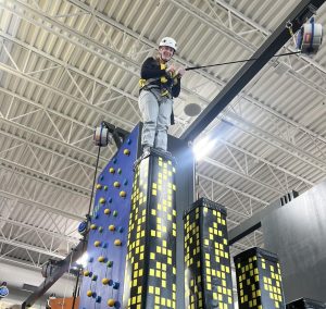 Abilene DeNunzio at the top of the rock climbing wall